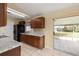 Kitchen with dark cabinets, neutral countertops, and sliding glass doors to screened patio at 83 Alameda Dr, Kissimmee, FL 34743