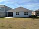 Home's backyard with a screened patio and grassy area at 835 Griffon Ave, Lake Alfred, FL 33850