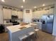 Island kitchen with stainless steel appliances and white cabinets at 835 Griffon Ave, Lake Alfred, FL 33850