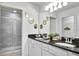 Bathroom with double sinks, granite countertops, and a walk-in shower at 8886 Geneve Ct, Kissimmee, FL 34747
