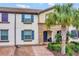 Two story townhouse with blue shutters and palm trees at 8886 Geneve Ct, Kissimmee, FL 34747
