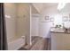 Bright bathroom with a shower-tub combo, stylish vanity, and wood-look flooring at 8919 Shine Dr, Kissimmee, FL 34747