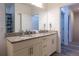 Bathroom featuring double sink vanity with granite countertops, and access to a hallway at 8919 Shine Dr, Kissimmee, FL 34747