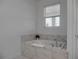 Relaxing bathroom with soaking tub and marble tile at 9234 Sommerset Hills Dr, Davenport, FL 33896
