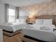 Two twin beds in a bedroom with floral wallpaper at 9234 Sommerset Hills Dr, Davenport, FL 33896
