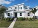 Two-story modern home with light stone and white exterior, landscaping, and walkway at 9234 Sommerset Hills Dr, Davenport, FL 33896