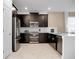 Modern kitchen features dark cabinetry, stainless steel appliances, and white countertops at 9234 Sommerset Hills Dr, Davenport, FL 33896
