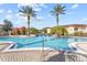 Inviting community pool surrounded by palm trees at 12209 Wild Iris Way # 110, Orlando, FL 32837
