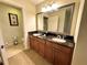 Bathroom featuring double sinks with granite countertops and a large mirror at 1350 Centre Court Ridge Dr # 401, Reunion, FL 34747