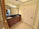 Tiled bathroom featuring double sinks, a large mirror, and gold accents at 1350 Centre Court Ridge Dr # 401, Reunion, FL 34747