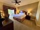 Cozy bedroom with a king-size bed, a ceiling fan, and a private balcony at 1350 Centre Court Ridge Dr # 401, Reunion, FL 34747
