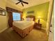 Comfortable bedroom with a queen bed, nightstand, and a window with decorative curtains at 1350 Centre Court Ridge Dr # 401, Reunion, FL 34747