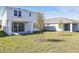 Spacious backyard with green grass, young trees, and a covered patio of home at 1503 August Gray Dr, Kissimmee, FL 34744