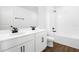 Modern bathroom featuring a double sink vanity, white cabinets, black hardware, and a tub with shower at 1503 August Gray Dr, Kissimmee, FL 34744