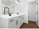 Bathroom boasts double sinks, white cabinets, black hardware, and a large mirror above at 1503 August Gray Dr, Kissimmee, FL 34744