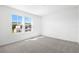 Bright bedroom with large windows offering a view of the neighboring home and plush gray carpeting at 1503 August Gray Dr, Kissimmee, FL 34744