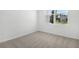 Empty bedroom featuring neutral carpeting, white walls, large window allowing for ample natural light at 1503 August Gray Dr, Kissimmee, FL 34744