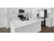 Modern kitchen featuring white cabinets, a large island, stainless steel appliances, and dark hardware at 1503 August Gray Dr, Kissimmee, FL 34744