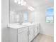 Bright bathroom with double vanity, white cabinets, large mirror, and tiled floor at 1509 August Gray Dr, Kissimmee, FL 34744