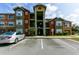 Exterior view of a multi-story apartment building displaying architectural details and designated parking spaces at 2203 Key West Ct # 435, Kissimmee, FL 34741