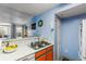 Cozy kitchen featuring orange cabinets, white marble countertops, stainless steel sink, and an open layout to the living area at 2203 Key West Ct # 435, Kissimmee, FL 34741