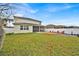 Spacious backyard featuring a large lawn, patio, fire pit, play area, and white vinyl fence at 2849 Shelburne Way, St Cloud, FL 34772