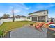 View of the home's backyard, featuring a fire pit, outdoor seating and well maintained lawn and landscaping at 2849 Shelburne Way, St Cloud, FL 34772
