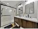 Modern bathroom with a glass enclosed shower, double vanity and black hardware at 2849 Shelburne Way, St Cloud, FL 34772