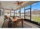 Screened lanai features ceiling fans, dining set, and relaxing outdoor furniture with a view of the backyard at 2849 Shelburne Way, St Cloud, FL 34772
