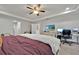 Bright main bedroom offers a ceiling fan, TV, desk with monitors and view of the ensuite at 2849 Shelburne Way, St Cloud, FL 34772