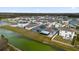 Aerial view of houses with solar panels and a pond at 3027 Serendipity Way, Davenport, FL 33896