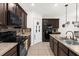Modern kitchen with dark cabinetry, stainless steel appliances, and tile backsplash at 3027 Serendipity Way, Davenport, FL 33896