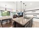 Open kitchen with island, breakfast bar seating, and view of living area at 3027 Serendipity Way, Davenport, FL 33896