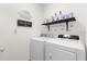 Bright laundry room with washer, dryer, and shelving at 3027 Serendipity Way, Davenport, FL 33896