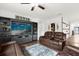 Spacious living room with brown leather reclining sofas and a large flat-screen TV at 3027 Serendipity Way, Davenport, FL 33896