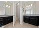 Double vanity bathroom with dark wood cabinets and updated fixtures at 3040 Cardillino Way, Kissimmee, FL 34741