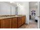 Bathroom featuring double sinks with granite countertops and wood cabinets, connecting to themed bedroom at 350 Pendant Ct, Kissimmee, FL 34747