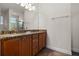 Bathroom featuring double sinks, granite countertops, wood cabinets, and a glass-enclosed shower at 350 Pendant Ct, Kissimmee, FL 34747