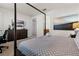 Bedroom featuring a canopy bed, dresser with mounted TV, and adjoining bathroom with modern finishes at 350 Pendant Ct, Kissimmee, FL 34747