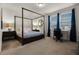 Bedroom with dark wood canopy bed, a work desk, and bright natural light from two windows at 350 Pendant Ct, Kissimmee, FL 34747