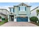 Charming two-story home featuring a brick driveway, teal shutters and a matching two-car garage door at 350 Pendant Ct, Kissimmee, FL 34747