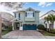 Charming two-story home featuring a brick driveway, teal shutters and a matching two-car garage door at 350 Pendant Ct, Kissimmee, FL 34747