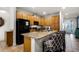 Large kitchen island with granite countertops, bar stool seating, and lots of natural wood cabinetry at 350 Pendant Ct, Kissimmee, FL 34747
