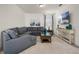 Cozy living room with neutral decor, a large sectional sofa, and a flat-screen television at 350 Pendant Ct, Kissimmee, FL 34747