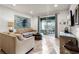Bright living room boasts neutral tones, tiled floors, and a sliding glass door to a covered outdoor area at 350 Pendant Ct, Kissimmee, FL 34747