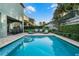 Inviting in-ground pool features a sun-shelf, brick trim, and an array of outdoor furniture at 350 Pendant Ct, Kissimmee, FL 34747