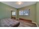 Cozy bedroom with green walls, wood-look laminate flooring, closet and natural light at 4201 Park Lake St, Orlando, FL 32803