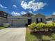 Front view of gray house with two-car garage and landscaping at 4310 Seven Canyons Dr, Kissimmee, FL 34746