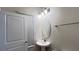 Well-lit half bathroom features modern fixtures, a pedestal sink, and tile floors at 4571 Tribute Trl, Kissimmee, FL 34746