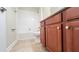Bathroom showcasing brown cabinets, vanity, toilet and tiled shower-tub with white tiling at 4571 Tribute Trl, Kissimmee, FL 34746